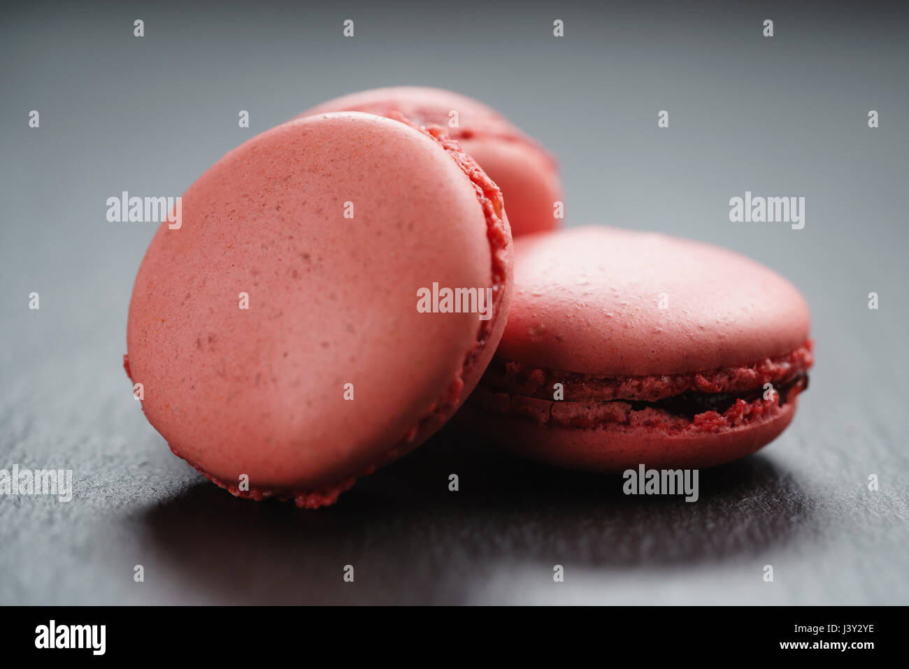 Macarons rose vif sur fond d'ardoise Banque D'Images