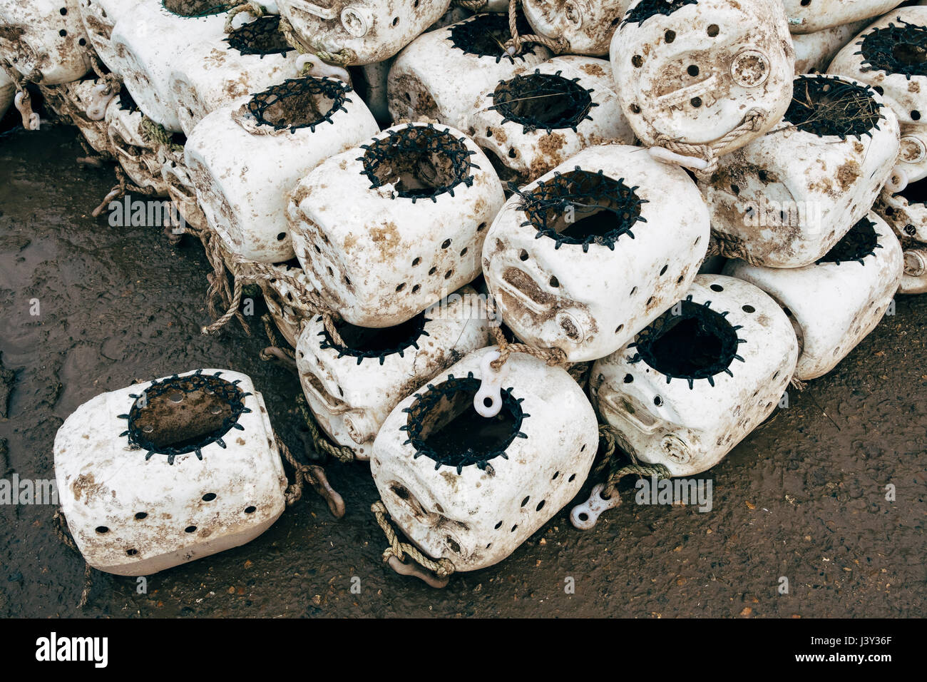 Pots de buccin empilés dans un port de pêche. Norfolk, Royaume-Uni. Banque D'Images