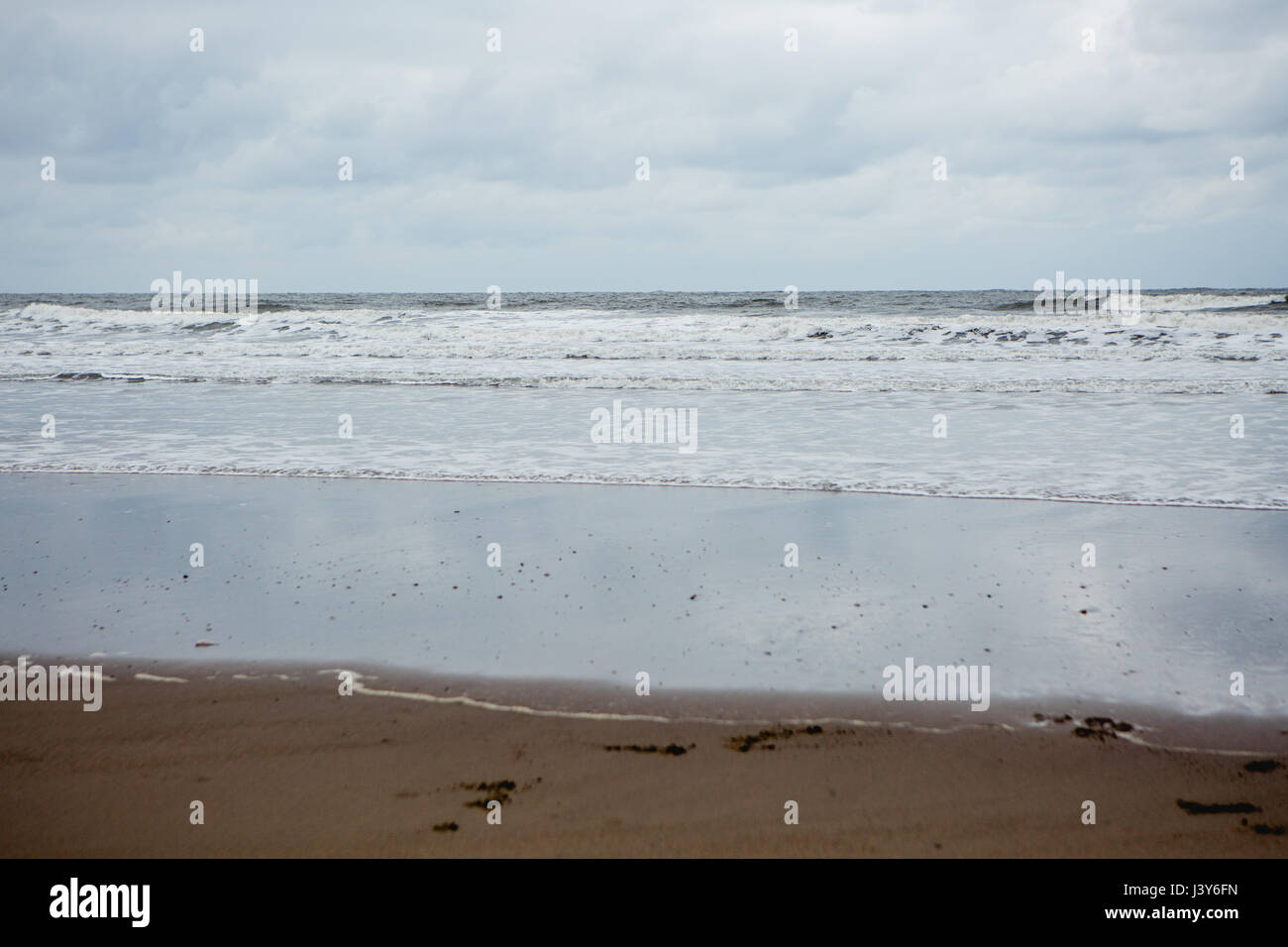 Plage, mer et vagues sur la côte de Whitby avec ciel nuageux Banque D'Images