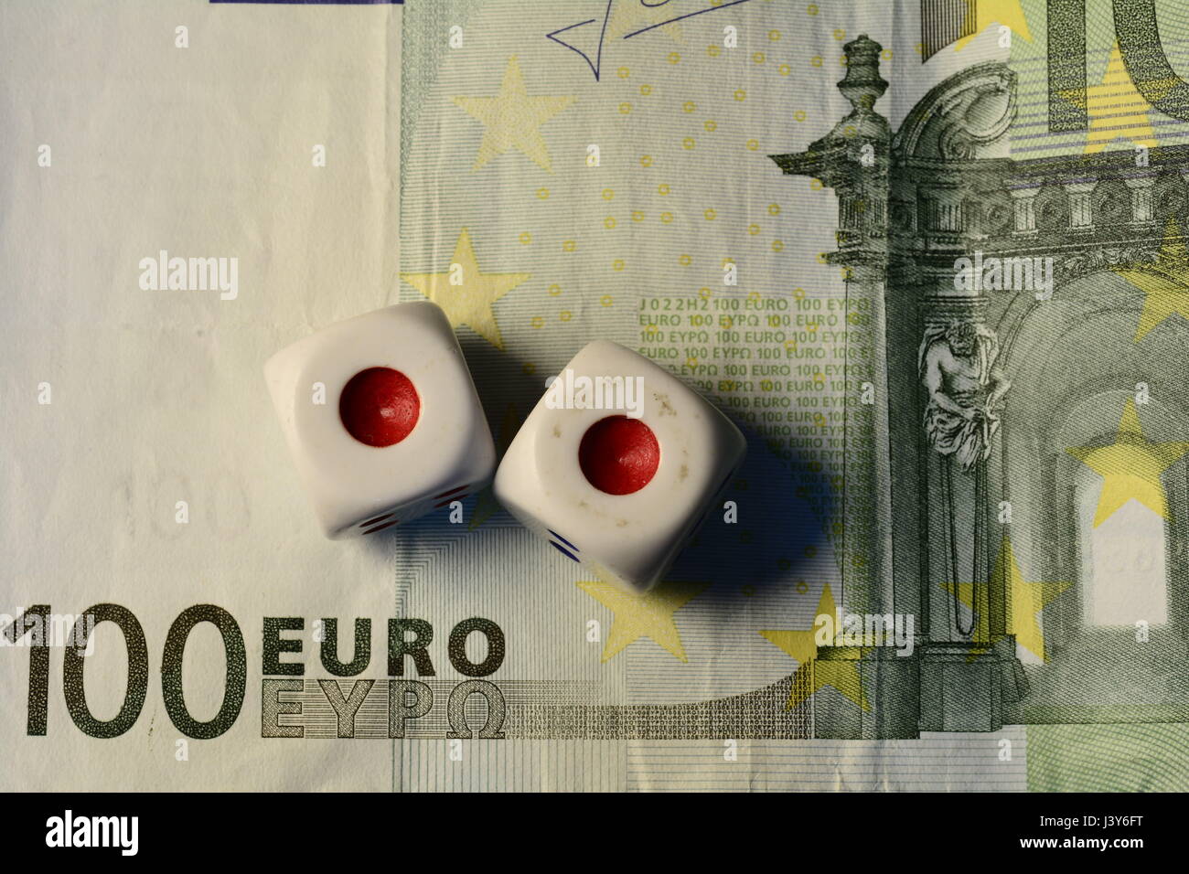 Deux dés blancs sur le dessus d'une centaine d'Euro note Banque D'Images