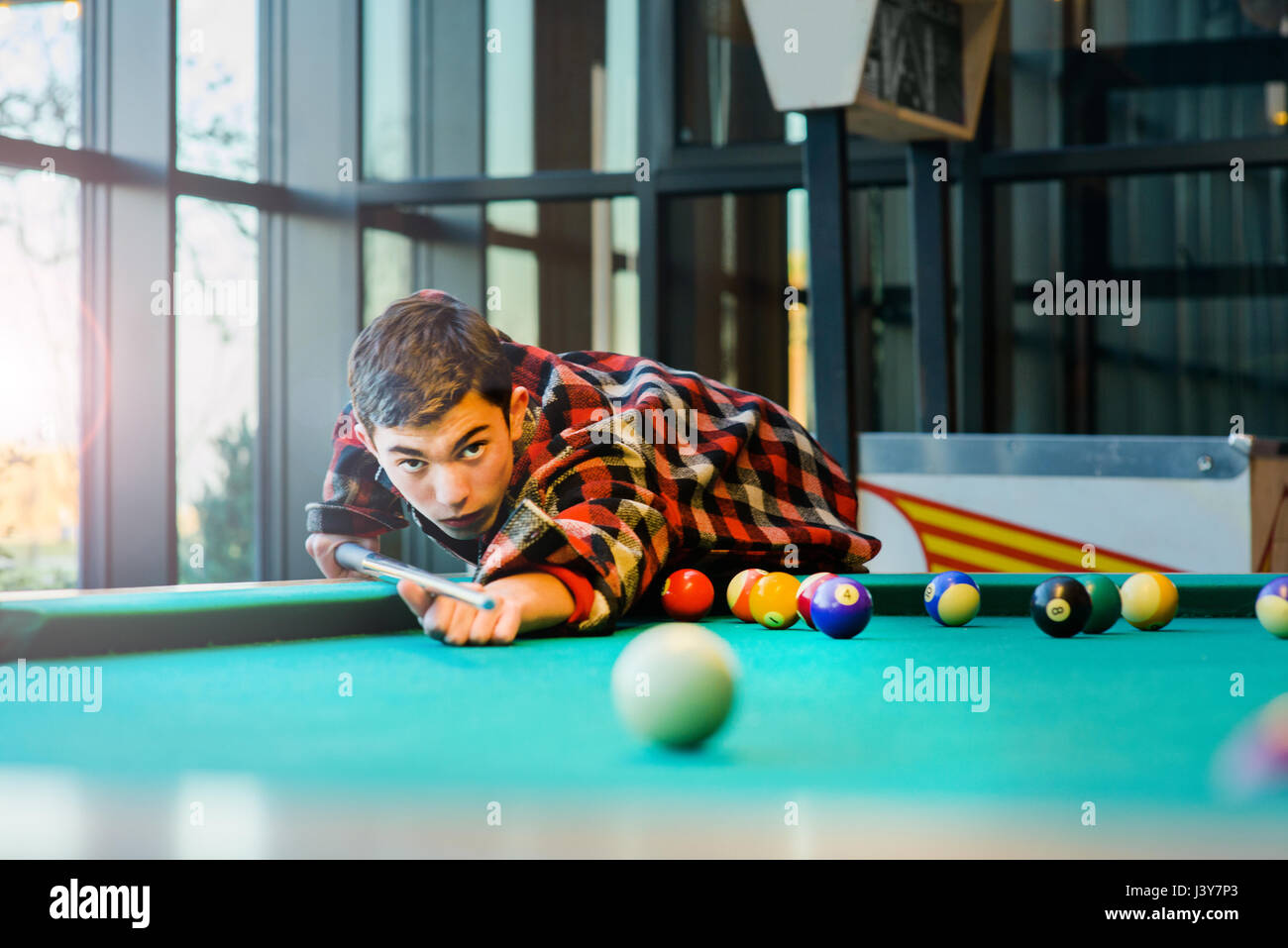 Teenage boy playing pool billard Banque D'Images