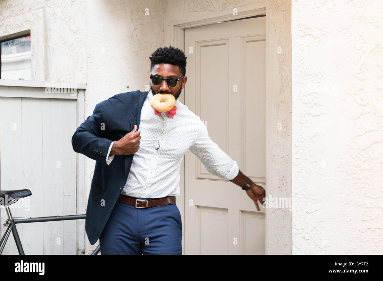 Young businessman eating donut et de fermeture de porte avant Banque D'Images