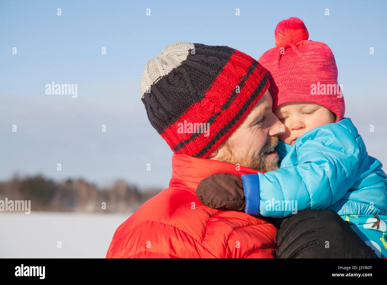 Père exerçant son jeune fils dans un paysage couvert de neige Banque D'Images