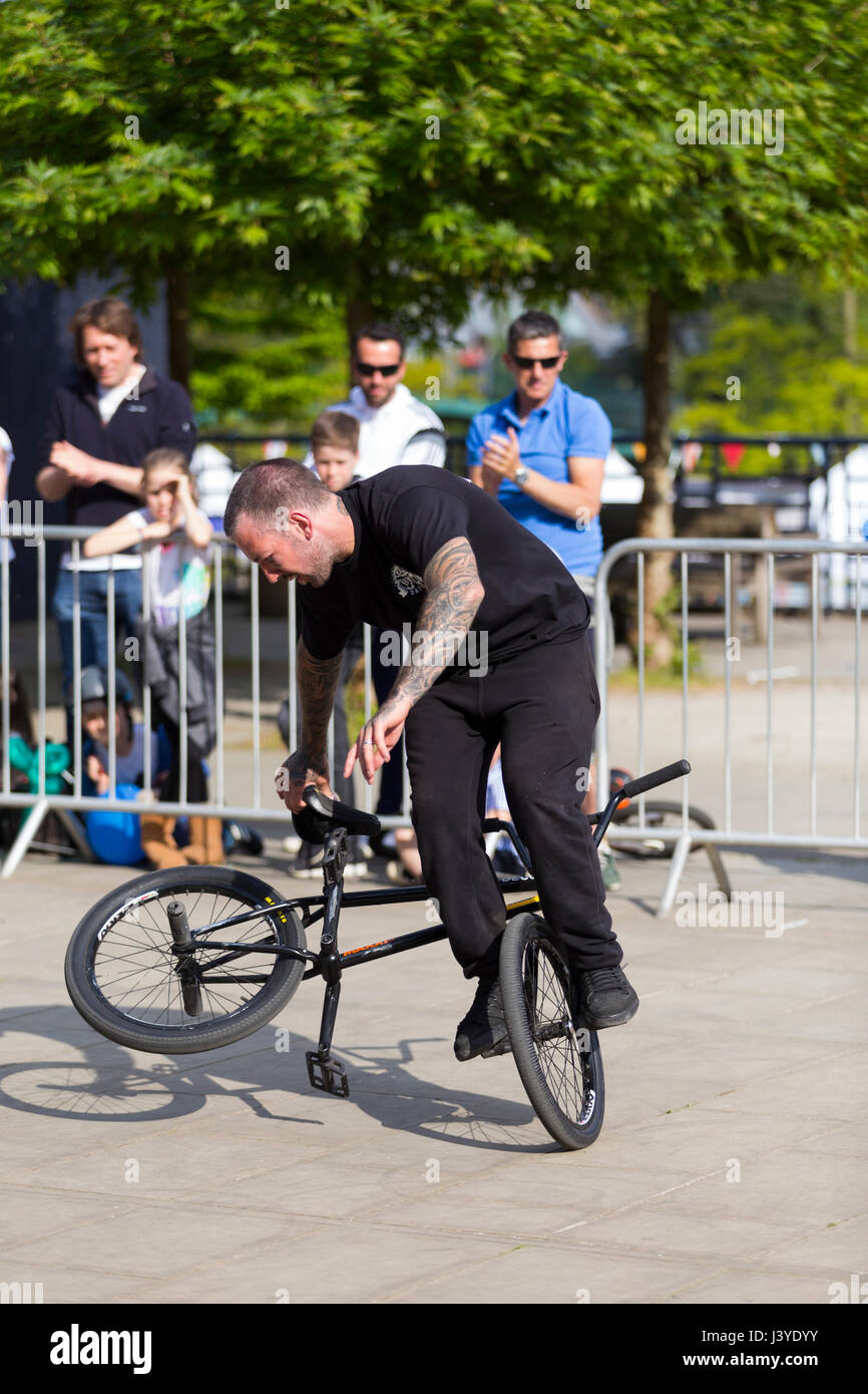 Un stunt cyclist riding a bike / cycle pendant une exposition performing stunts / wheelies et autres truc / astuces. UK. (87) Banque D'Images