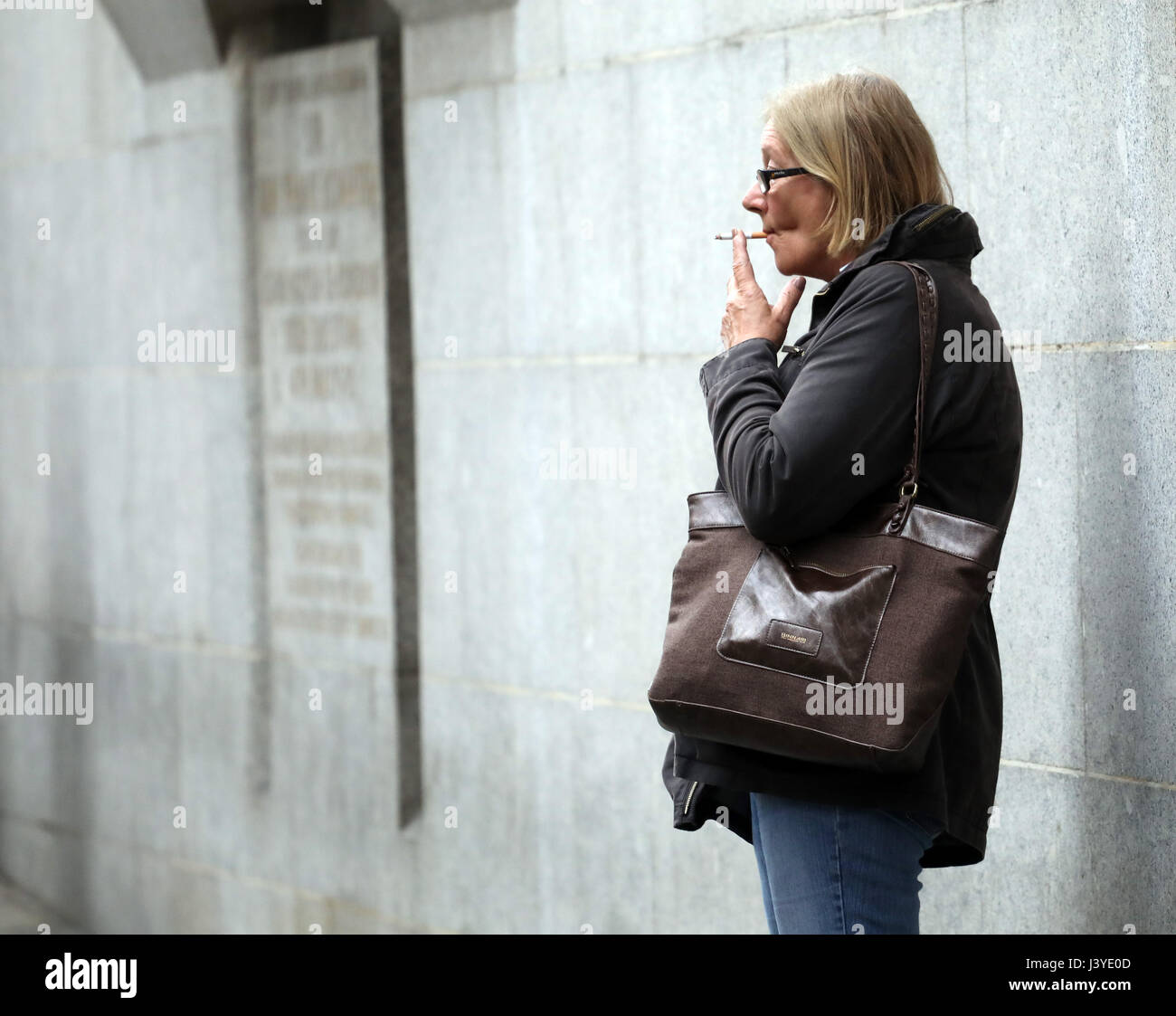 Femme fumer dehors building Banque D'Images