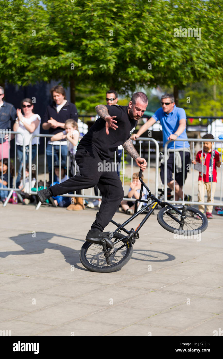 Un stunt cyclist riding a bike / cycle pendant une exposition performing stunts / wheelies et autres truc / astuces. UK. (87) Banque D'Images