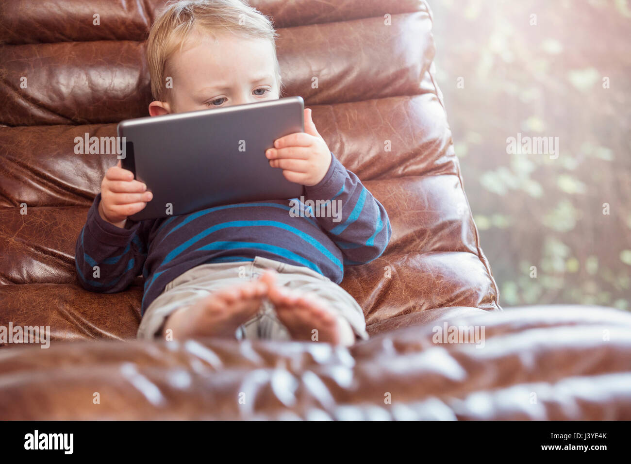 Bébé garçon vous coucher sur un président à la tablette à Banque D'Images