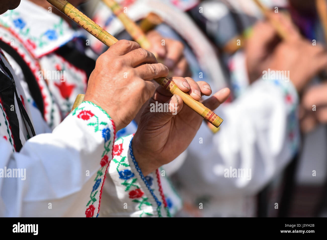 Les gens en costumes traditionnels le chant à flûtes en bois Banque D'Images