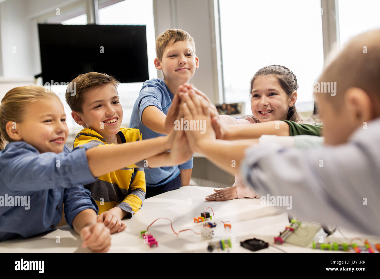 Des enfants heureux à l'école de robotique high five Banque D'Images