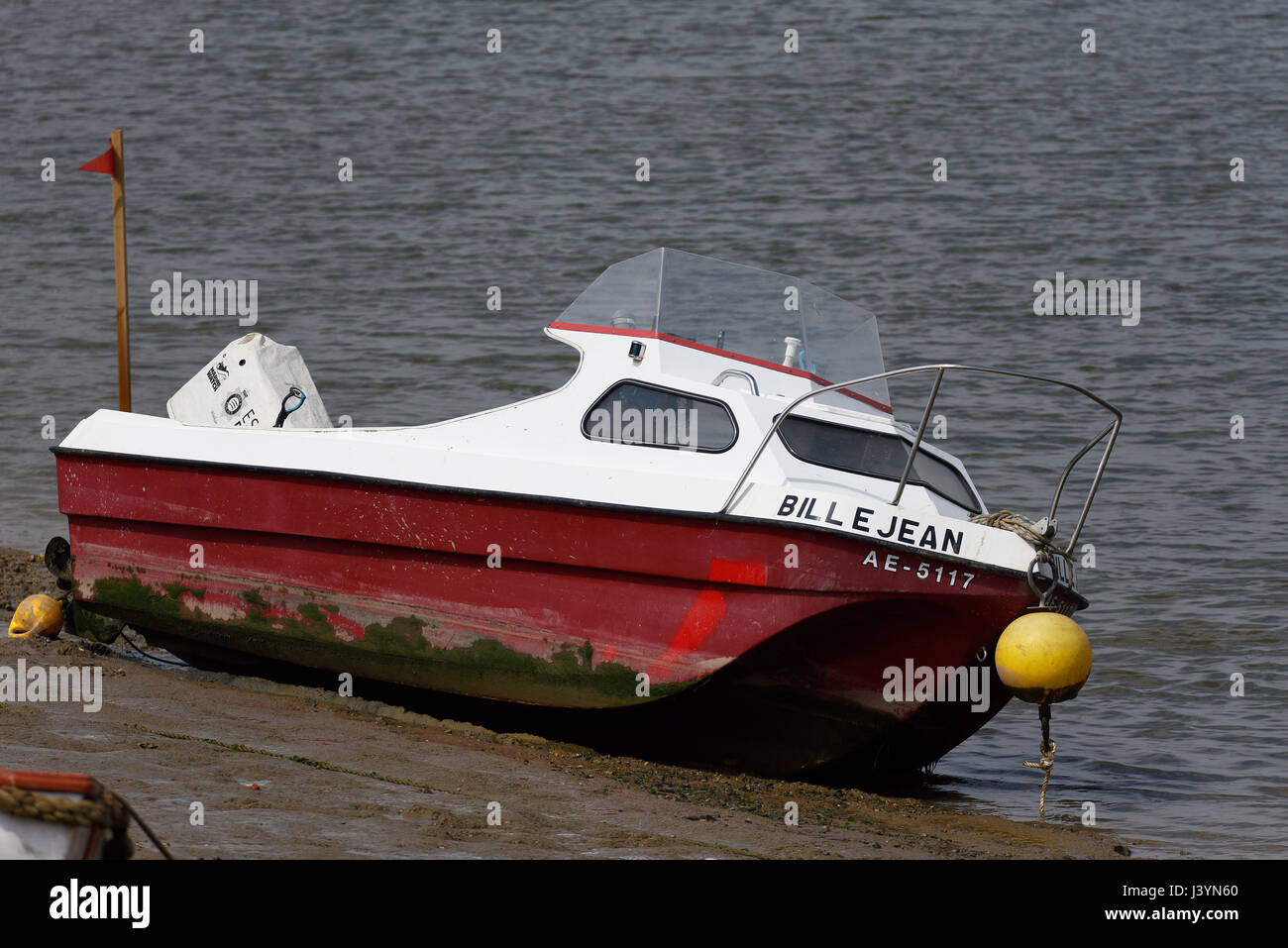 Un petit bateau à moteur nommé Billie Jean à Maldon, Essex, sur la rivière Blackwater. Échouée sur la boue avec des bouées et un garde-boue Banque D'Images