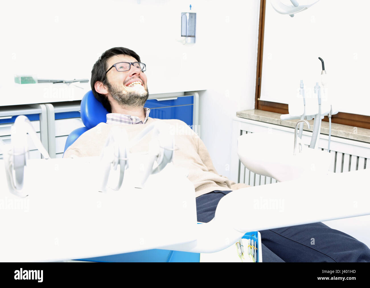 Des profils homme assis dans la chaire de chirurgie dentaire dentiste avec lumière ambiante très lumineux Banque D'Images