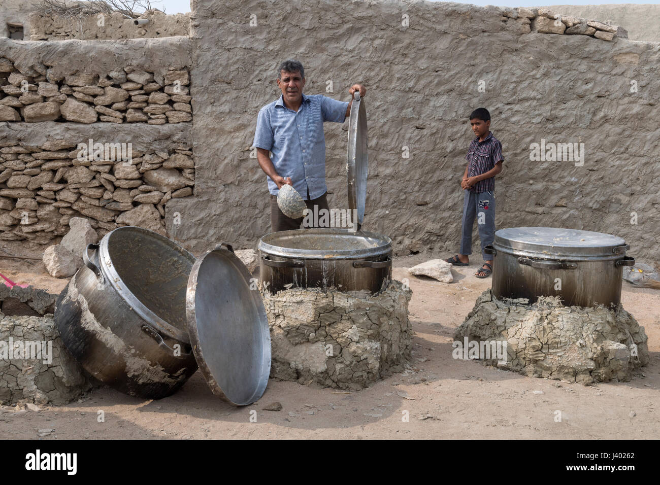 L'homme défait Halim pot -porridge local- qui a cuit lentement pendant 12 heures, mariage traditionnel, l'île de Qeshm, Tabl, Province Hormozgan Banque D'Images