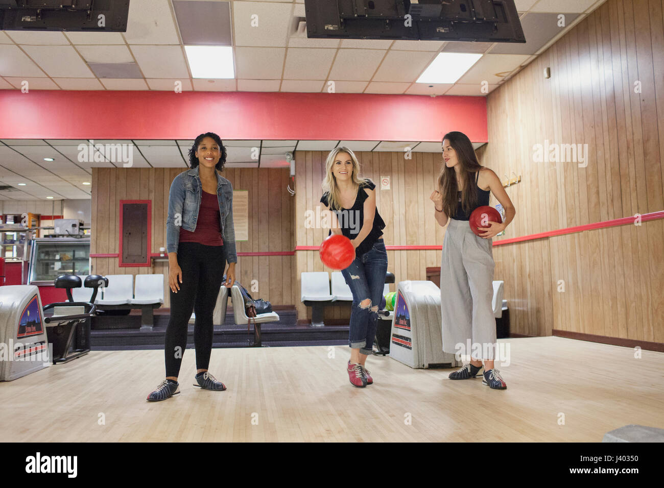 Les jeunes femmes un bowling avec des amis. Banque D'Images