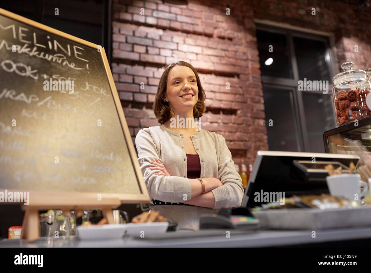 Femme heureuse ou barmaid au comptoir café Banque D'Images