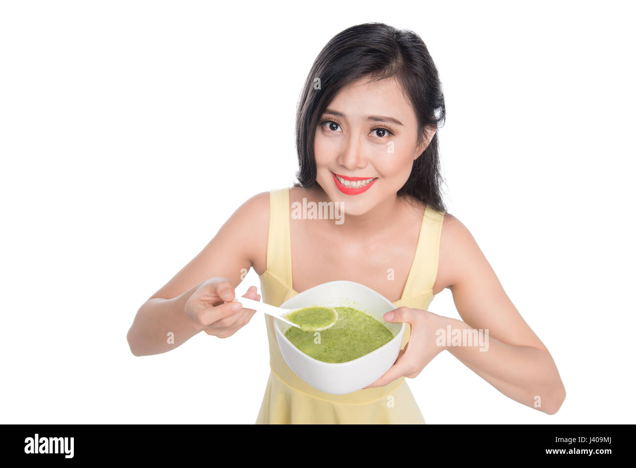 Portrait of asian woman eating/tenant une assiette de soupe aux légumes verts Banque D'Images