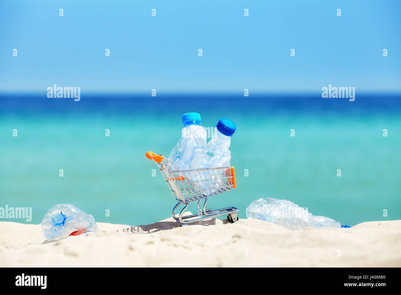 Panier miniature avec des bouteilles en plastique vides laissés par touriste sur une plage tropicale, la pollution de l'environnement concept photo, selective focus. Banque D'Images