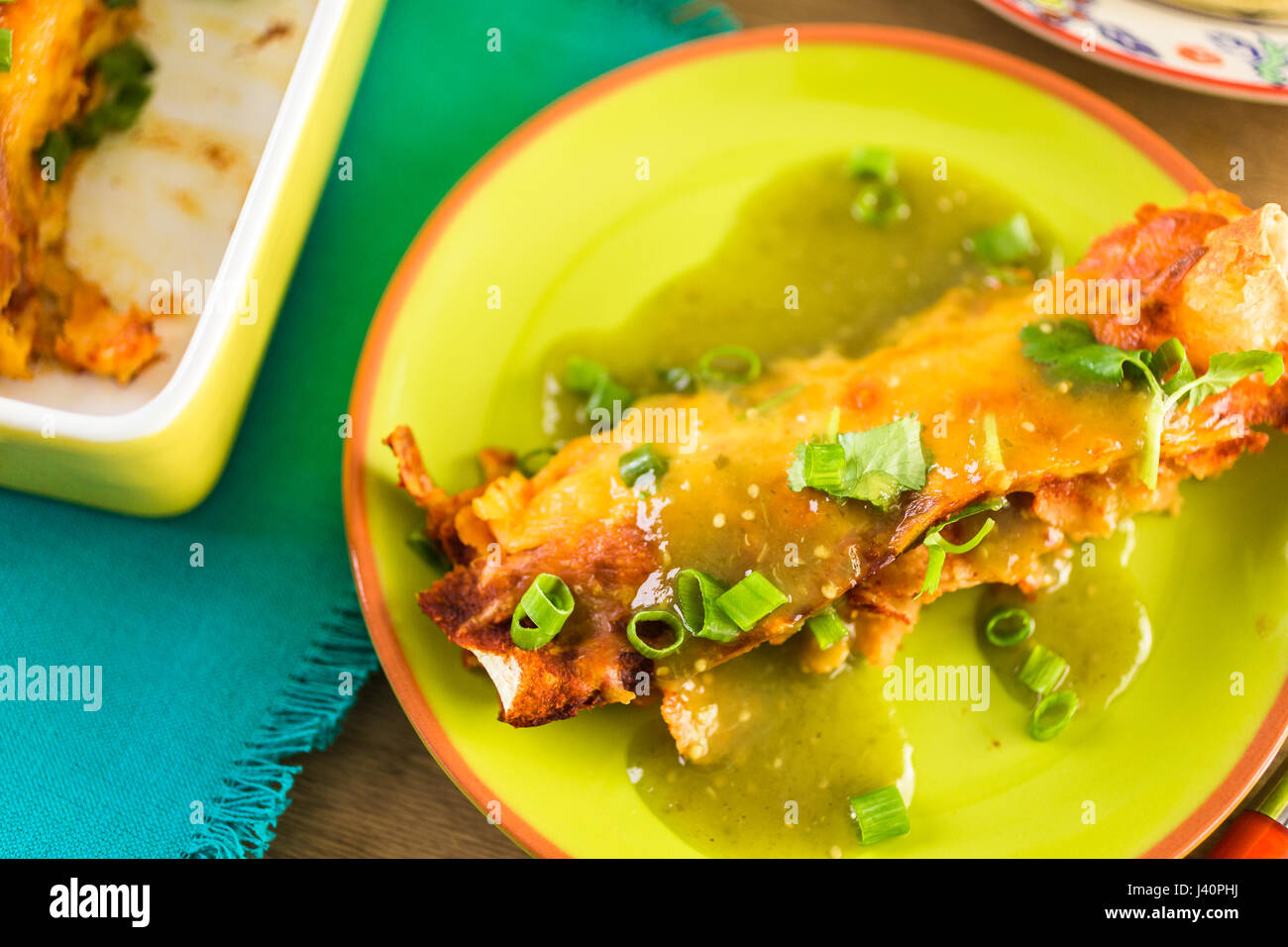 Enchiladas au poulet avec le fromage cheddar et de la sauce. Banque D'Images