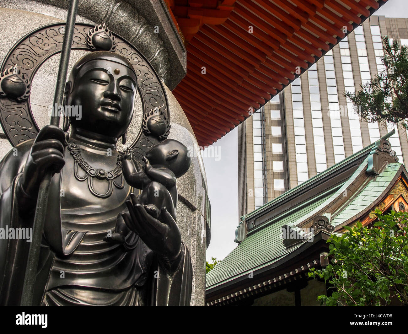 Un enfant a tenu dans la paume de la main de Dieu, de la Statue de la divinité bouddhiste, une part avec le personnel, l'autre tenant un bébé nouveau-né. Shitsuenji Temple, Hiroo, Banque D'Images