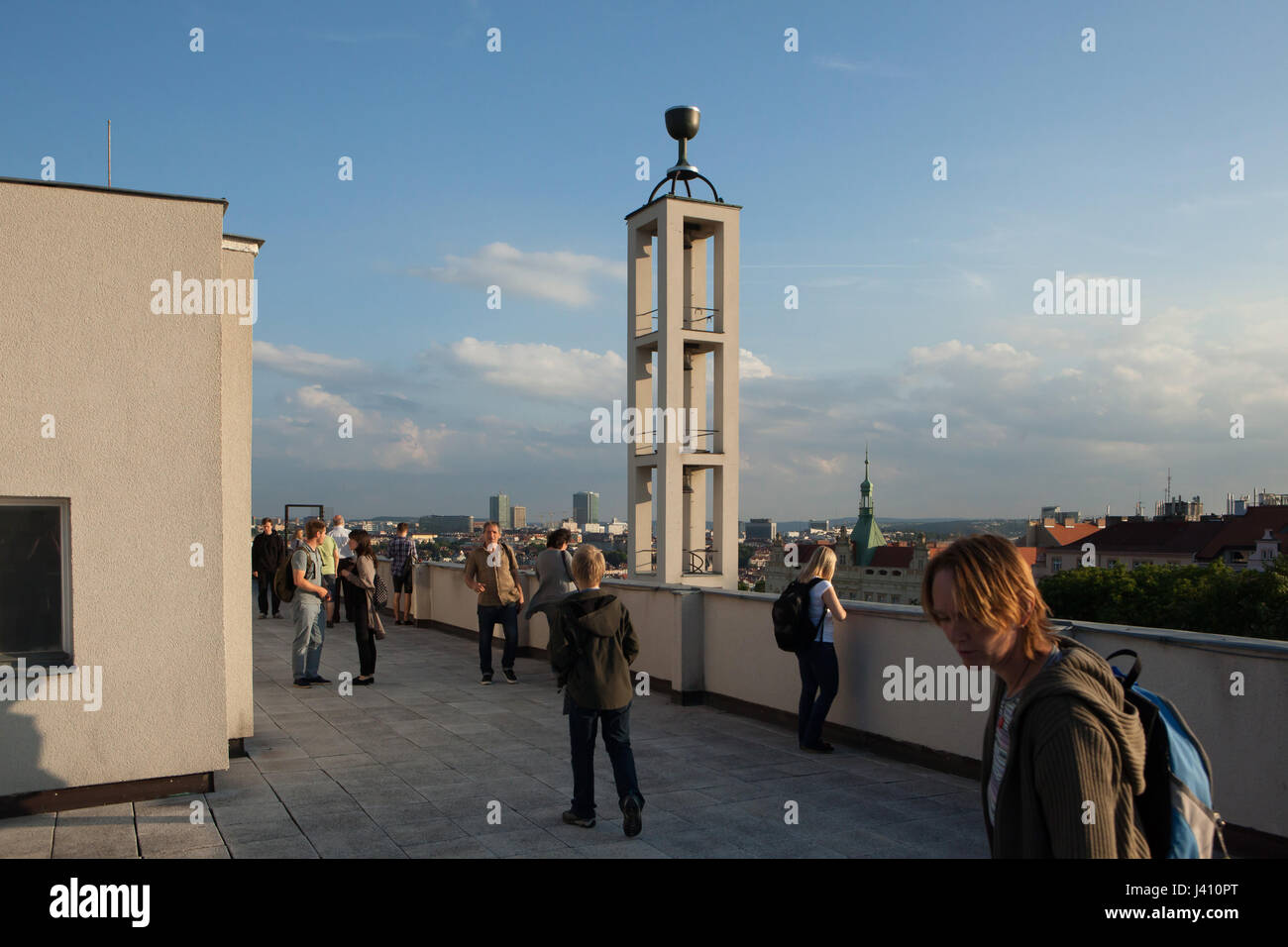 Personnes visitent la terrasse de toit de la Maison de la congrégation de l'Église hussite tchécoslovaque (Husův sbor) dans le quartier de Vinohrady à Prague, en République tchèque, le 10 juin 2016, l'occasion de visiter généralement fermées certaines parties de l'architecture religieuse durant le festival annuel monuments Nuit des Eglises (AC) kostelů. Le clocher fonctionnaliste de la congrégation conçu par l'architecte moderniste Tchèque Pavel Janák et construit en 1930-1935 vu dans l'arrière-plan. Banque D'Images