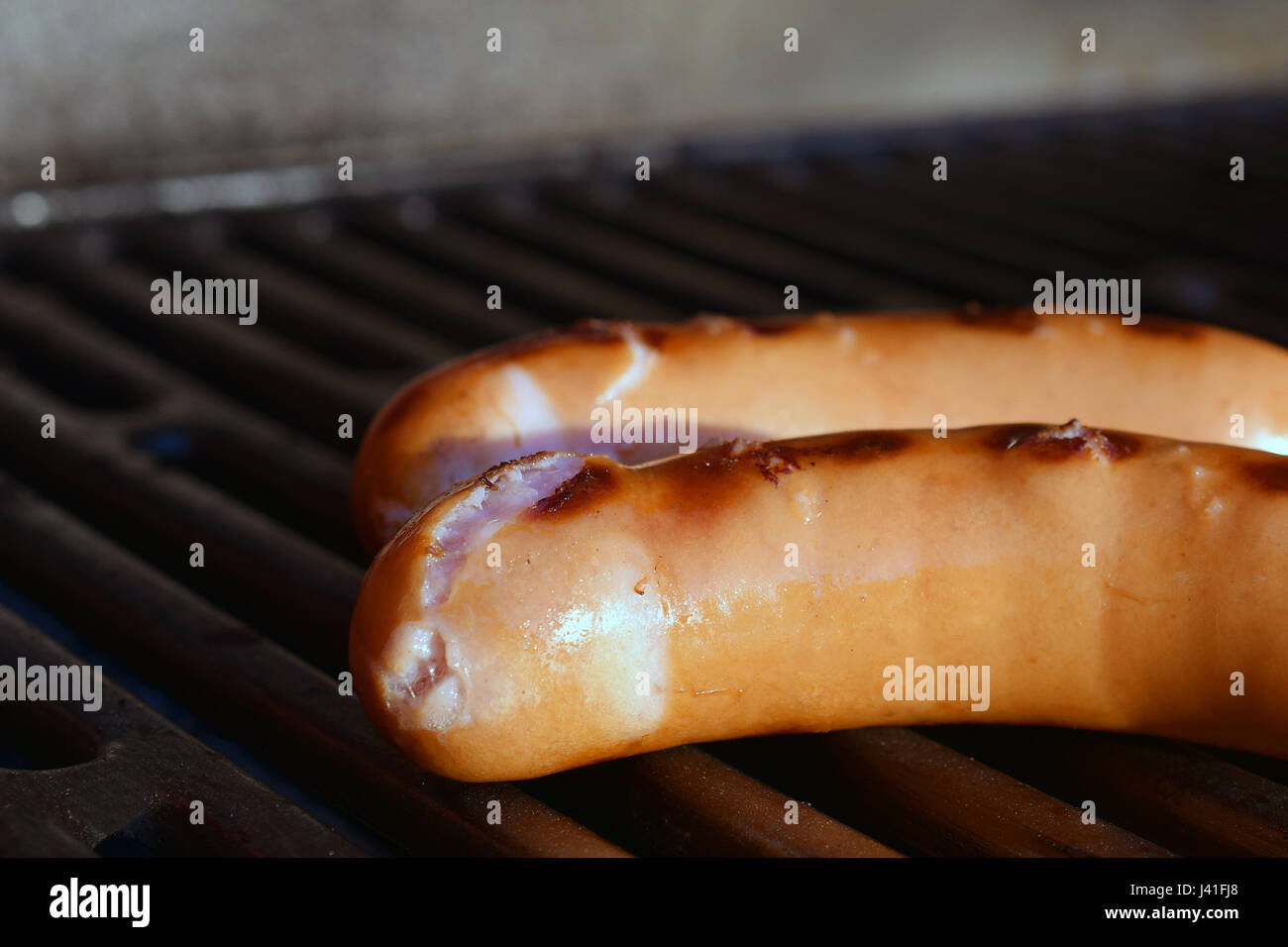 Deux saucisses sur le gril du barbecue. L'accent sur le premier plan. Close up image horizontale. Banque D'Images