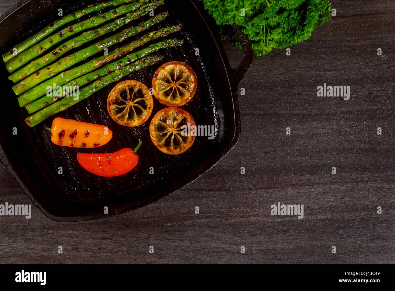 Asperges grillées au citron bio poivre dans une poêle grill Banque D'Images