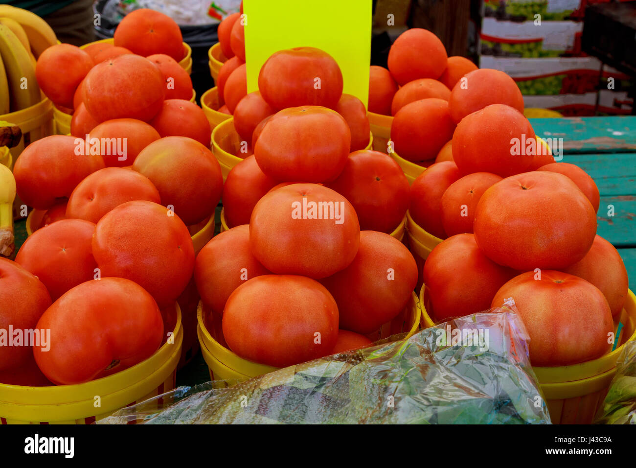 Frais de la ferme tableau signe de l'écran avec des paniers remplis de tomates rouges cultivés localement au marché agricole local Banque D'Images