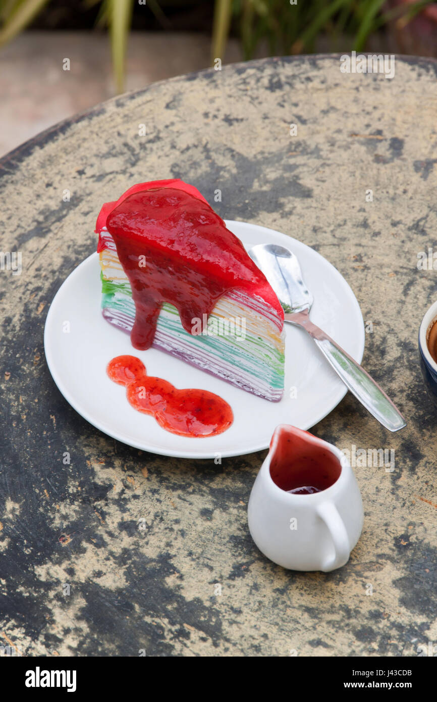 Gâteau de crêpe et arc-en-ciel café expresso chaud dans la maison. Côté  jardin avec sauce aux fraises gâteau de crêpe Photo Stock - Alamy