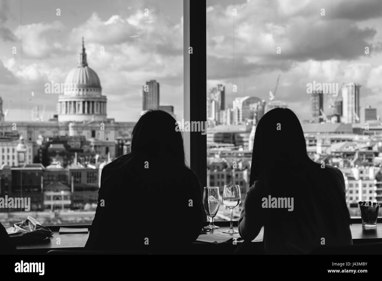 Silhouette de deux personnes bénéficiant d'un vin donnant sur la cathédrale St Paul et les toits de Londres Banque D'Images