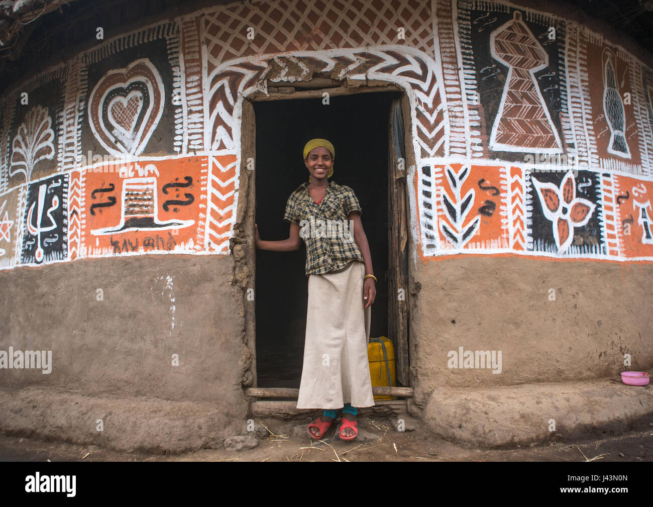 Ethiopian femme debout devant sa maison, peint traditionnel Kembata Alaba, Kuito, Ethiopie Banque D'Images