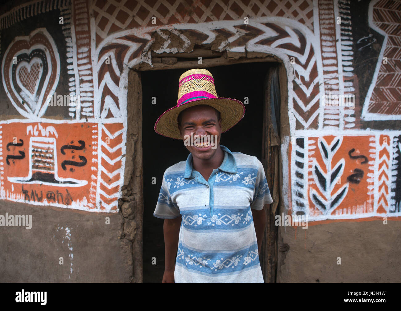 Homme éthiopien avec un chapeau debout devant sa maison, peint traditionnel Kembata Alaba, Kuito, Ethiopie Banque D'Images