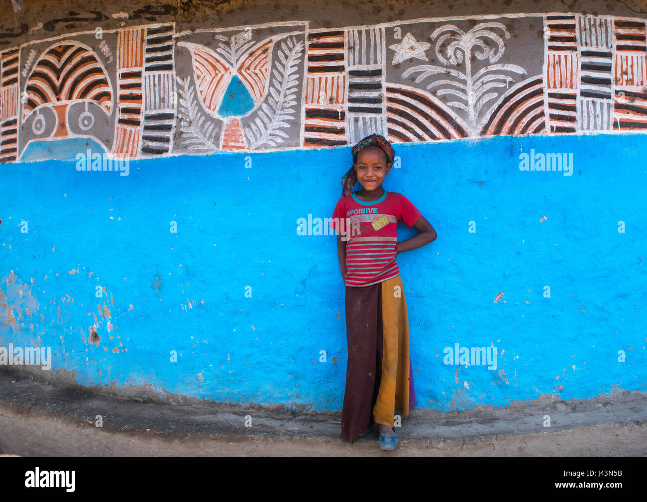 Éthiopienne debout devant sa maison, peint traditionnel Kembata Alaba, Kuito, Ethiopie Banque D'Images