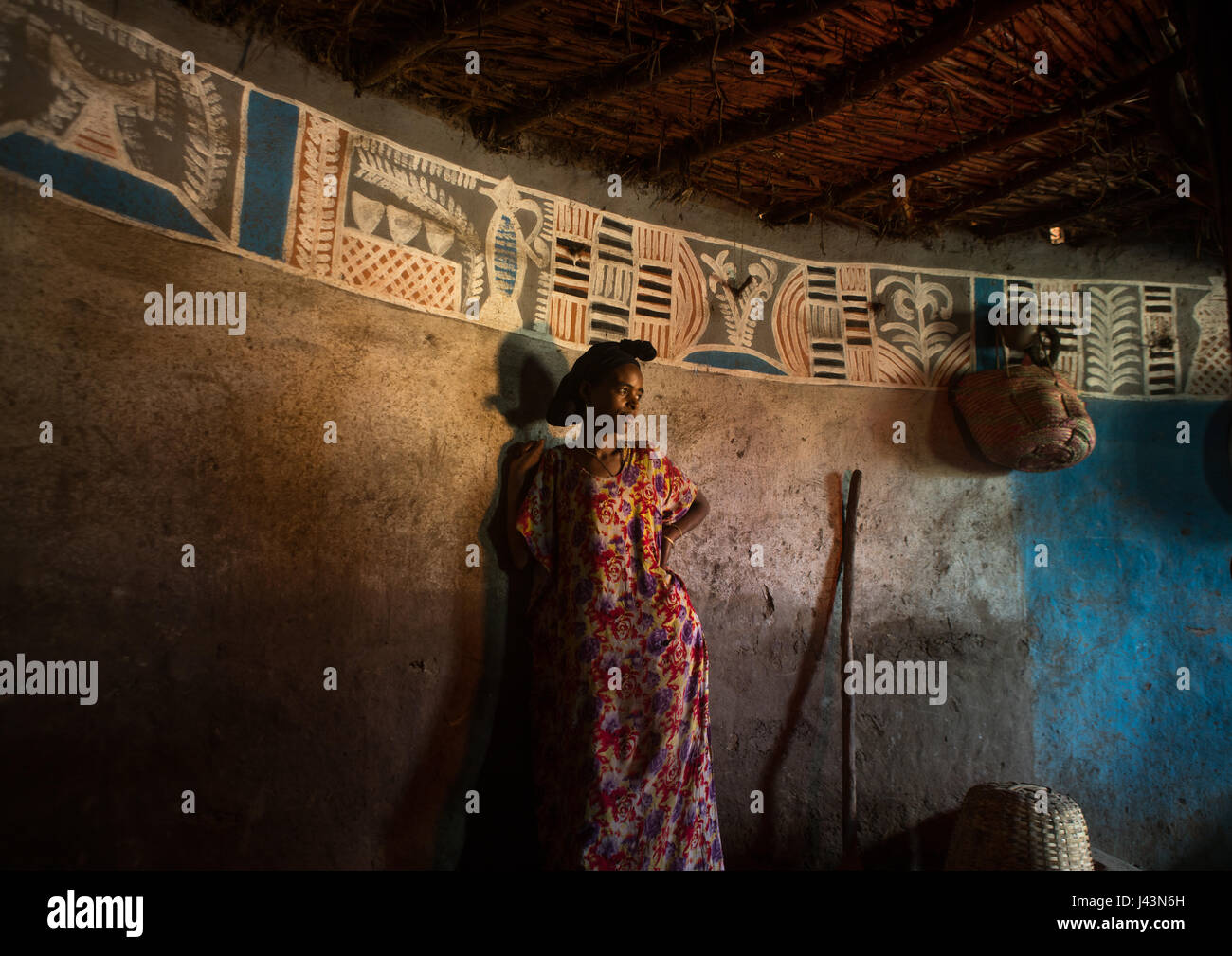 Femme éthiopienne à l'intérieur de sa maison traditionnelle peint et décoré, Kembata Alaba, Kuito, Ethiopie Banque D'Images