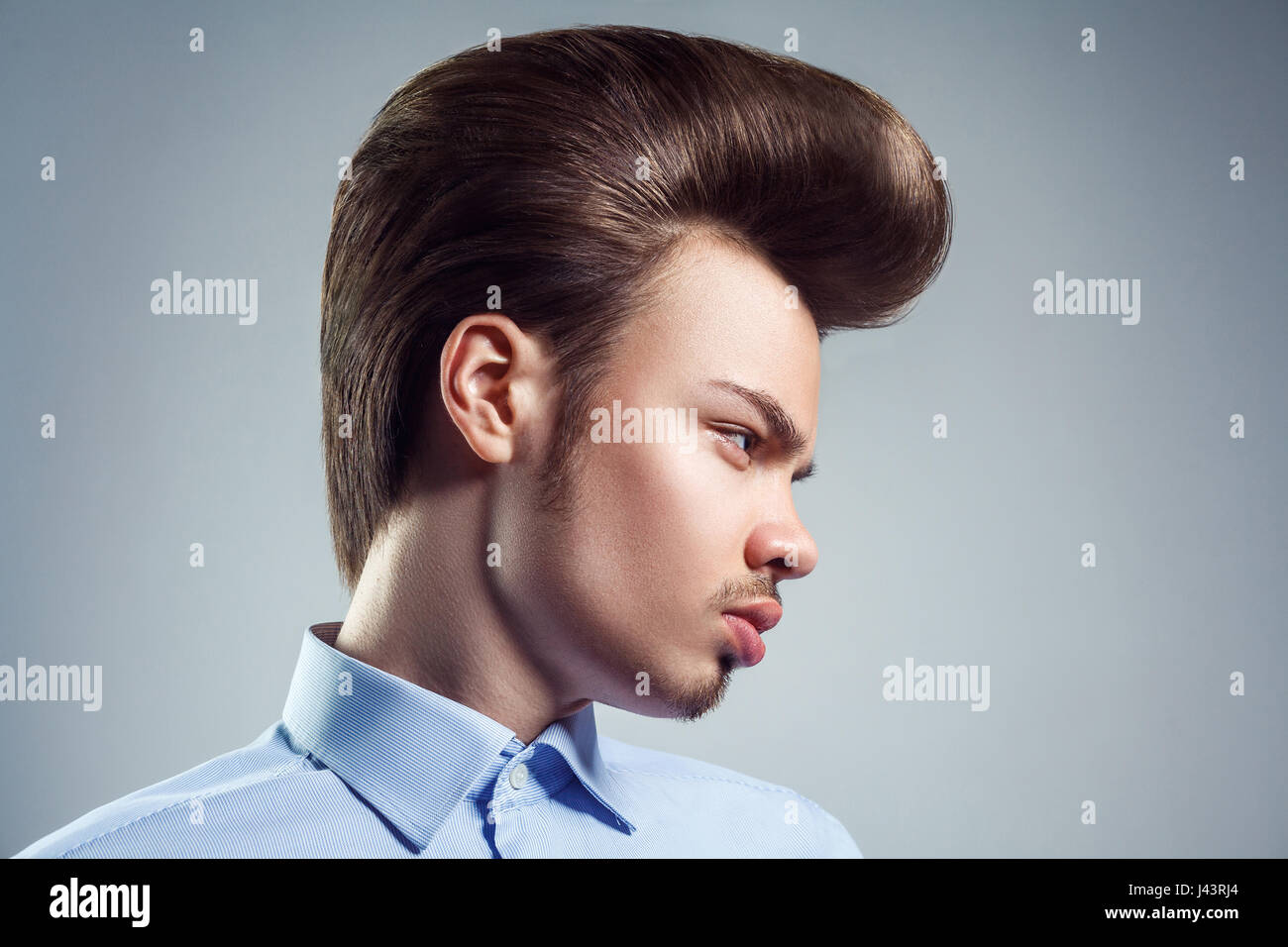 Vue latérale du jeune homme avec retro classic pompadour hairstyle. studio shot. Banque D'Images