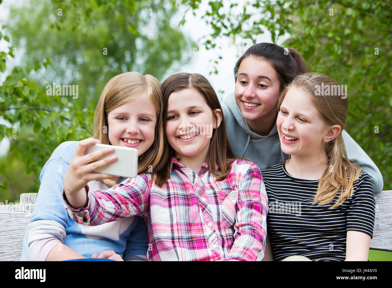 Groupe de Jeunes filles posant pour en Selfies Park Banque D'Images