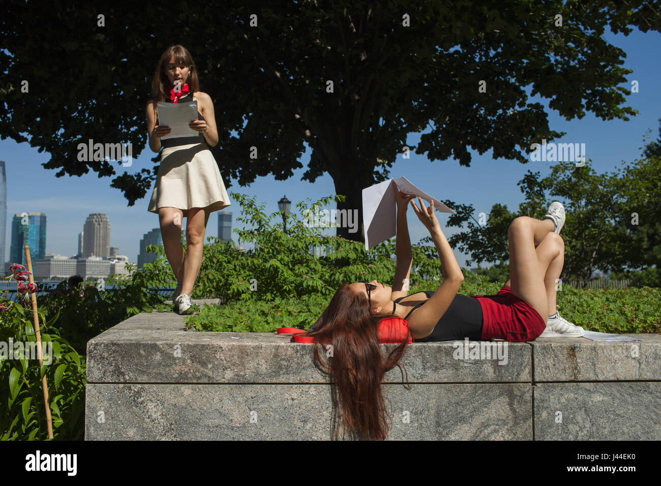 Deux jeunes femmes sur le rebord d'un jardin Banque D'Images