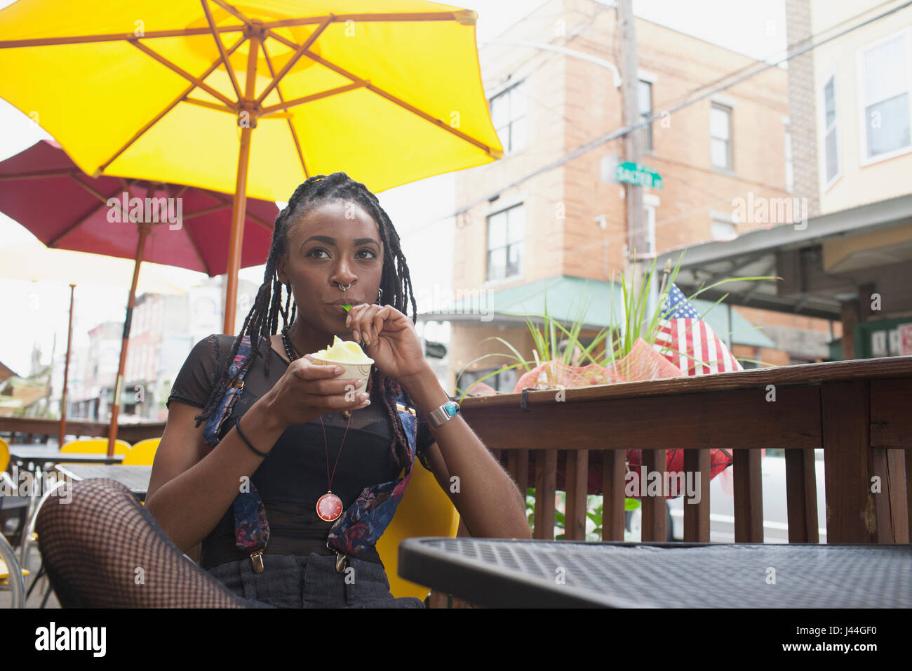 Une jeune femme de manger du yogourt glacé. Banque D'Images