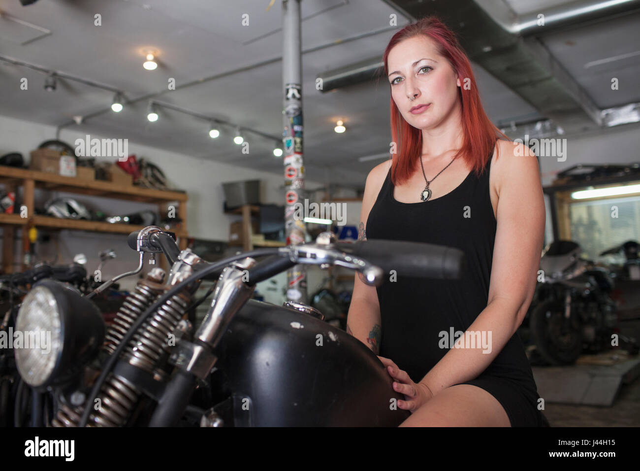 Une jeune femme avec une moto. Banque D'Images