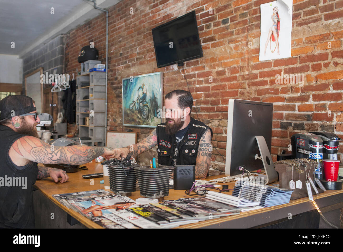 Deux jeunes hommes se serrer la main sur un bureau. Banque D'Images