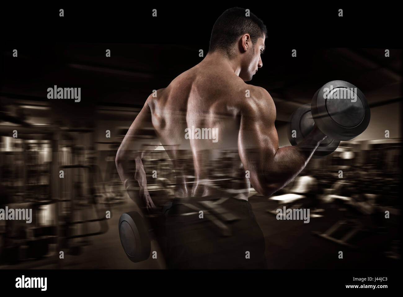 Athletic man training biceps sur fond de sport Banque D'Images