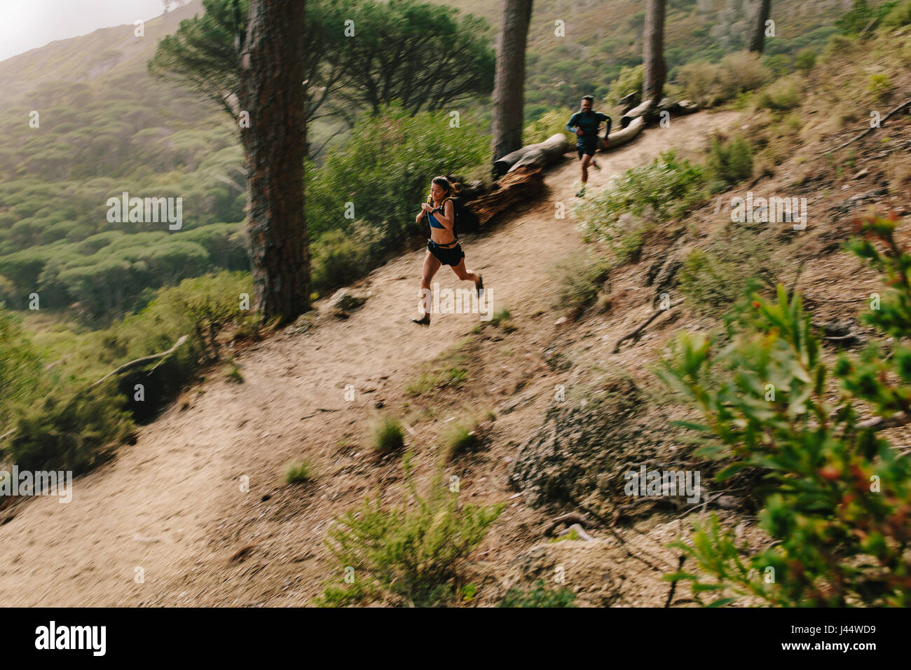 Jeune couple trail running sur un chemin de montagne. Porteur de vous entraîner dans une nature magnifique. Banque D'Images