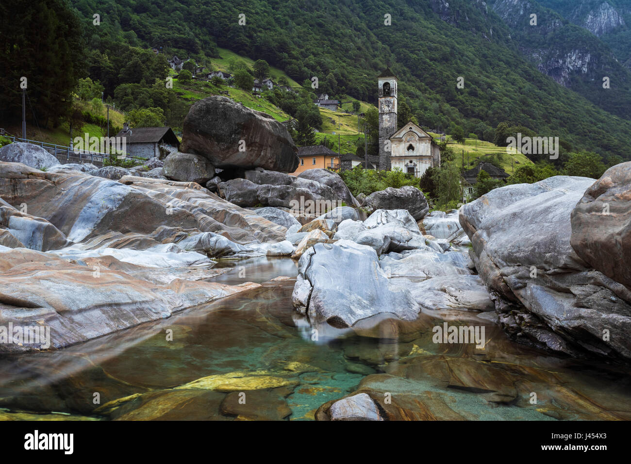 Les roches sur le lit de la rivière Verzasca et l'église de Lavertezzo, Valle Verzasca, Tessin, Suisse. Banque D'Images