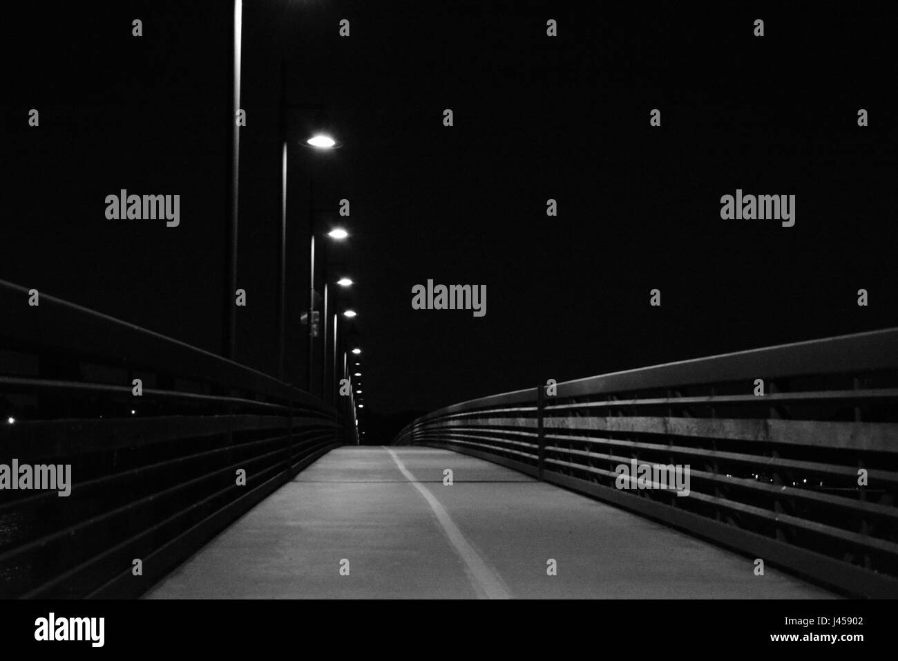 Photo en noir et blanc granuleux de lumières éclairant l'oiseau de nuit passerelle à l'extrémité nord de White Rock Lake à Dallas, Texas Banque D'Images