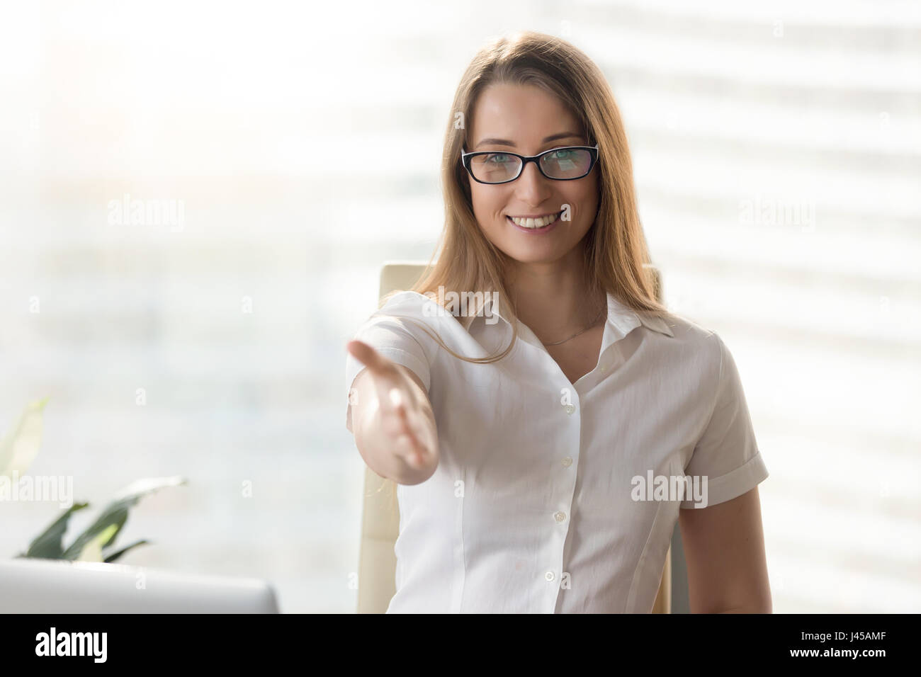 Happy businesswoman reaching hand for handshake Banque D'Images
