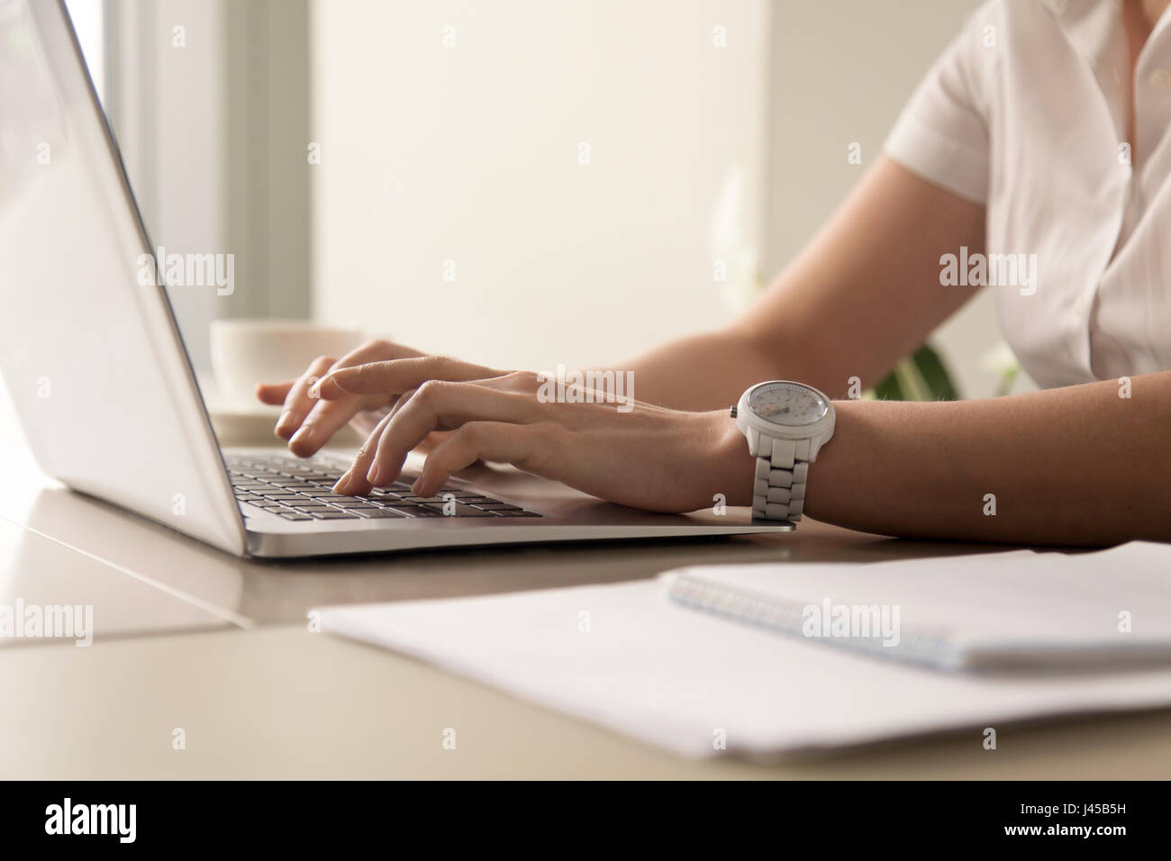 Les mains de womans typing on laptop sur le lieu de travail Banque D'Images