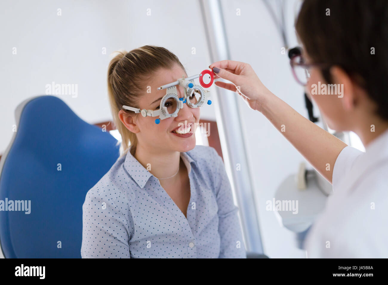 Femme faisant l'essai d'oeil avec l'optométriste in medical office Banque D'Images