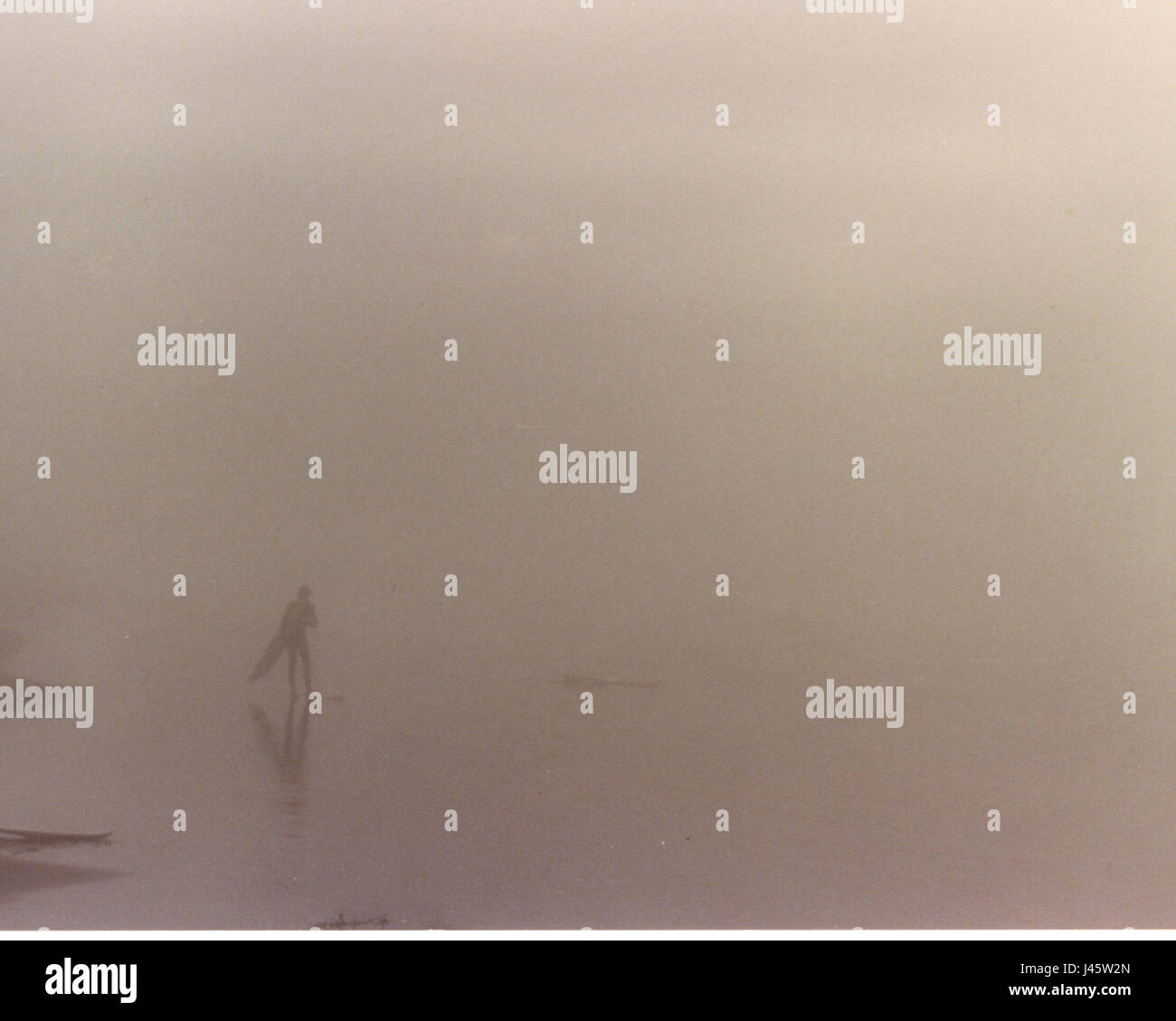 Surfer seul sur la plage dans un épais brouillard Banque D'Images