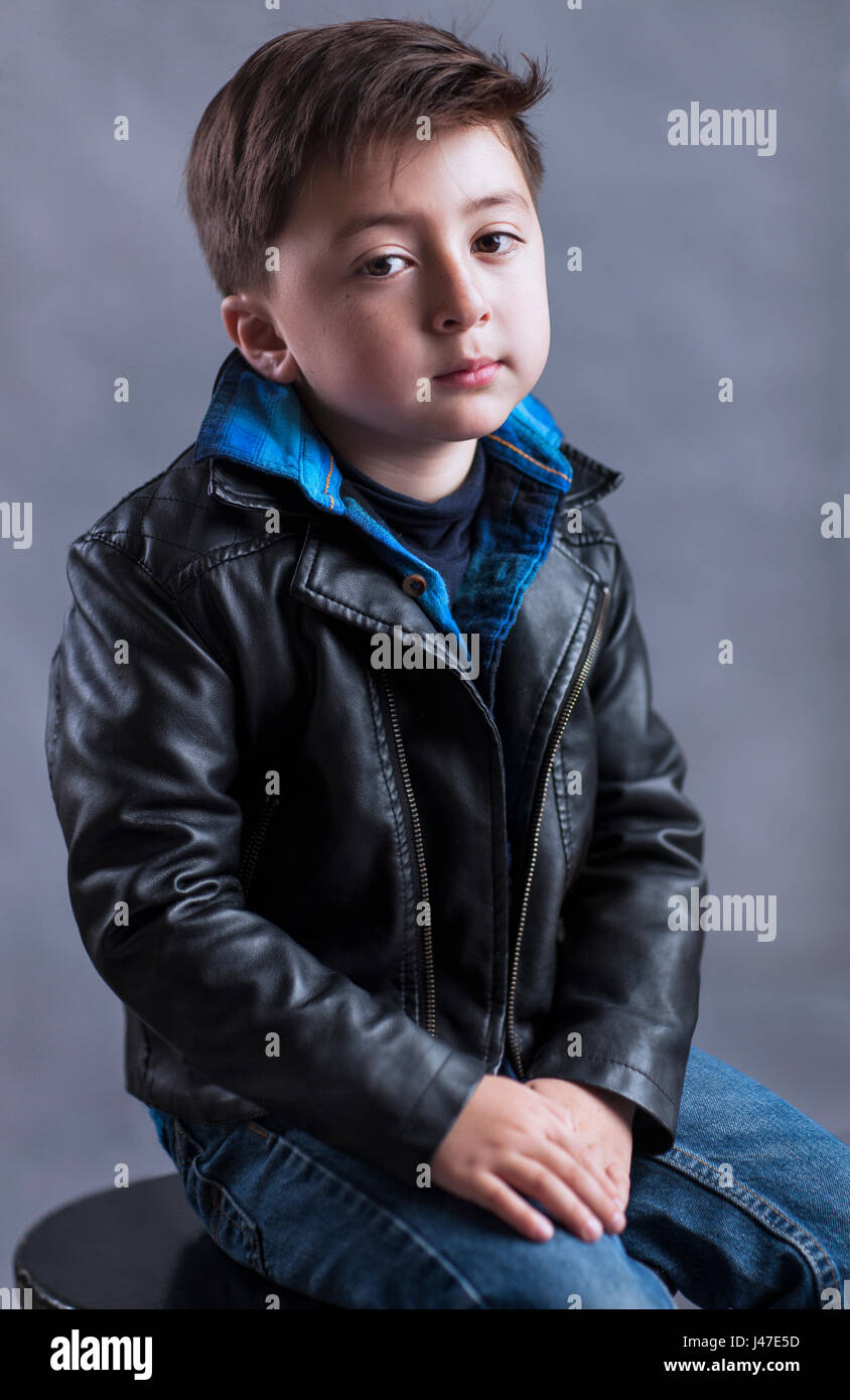 Le punk rock and roll petit garçon avec graisseur rockabilly coupe portant un blouson de moto en cuir noir et bleu denim jeans Banque D'Images