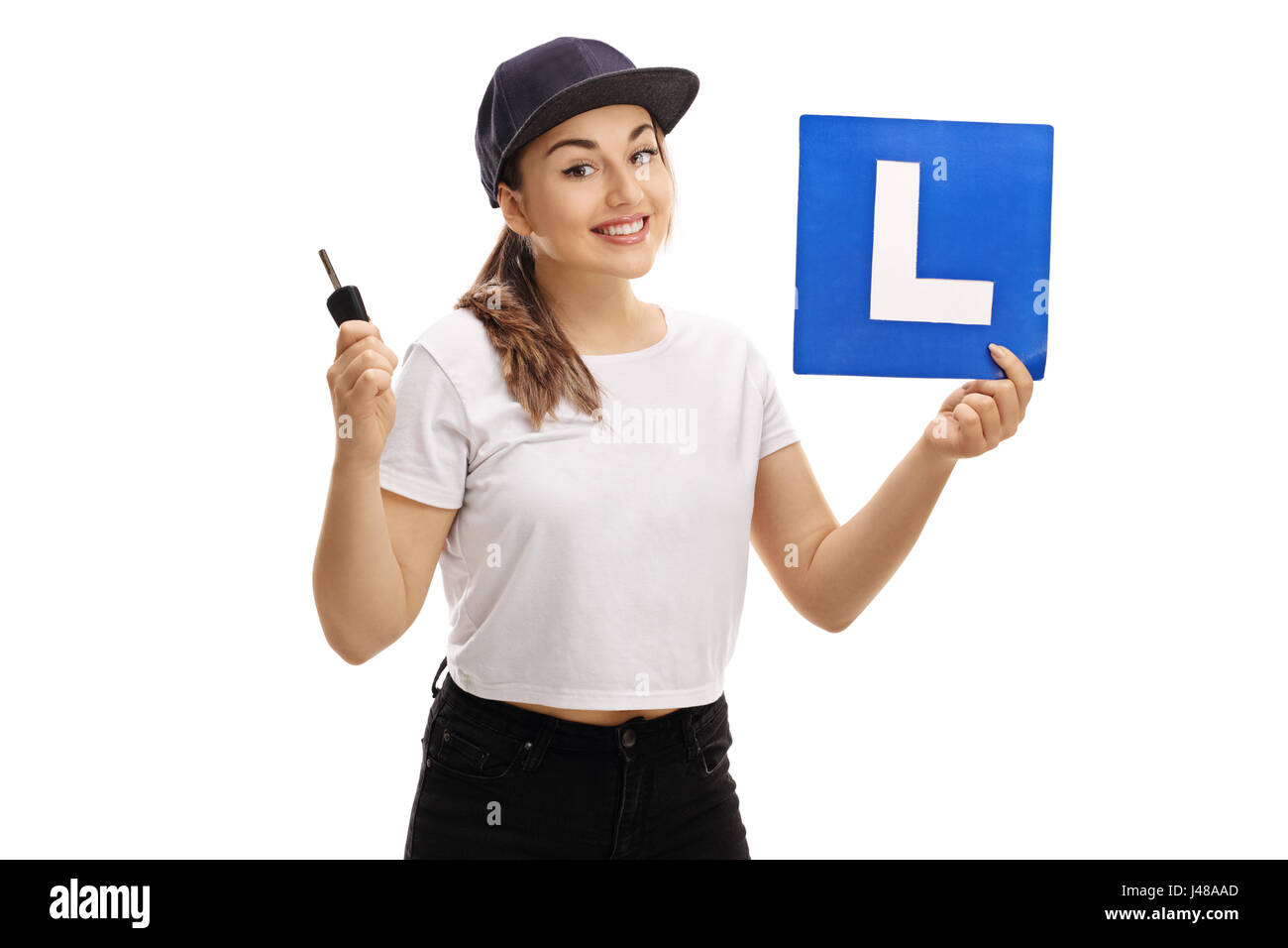 Teenage girl holding une clé de voiture et d'un L-sign isolé sur fond blanc Banque D'Images