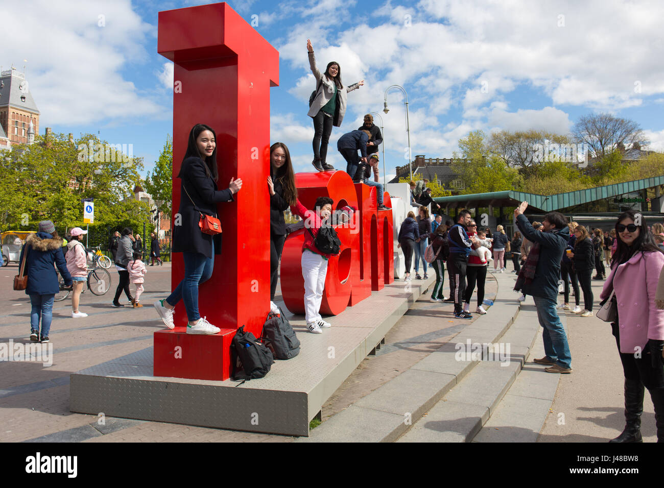 Les touristes de la prise de vue à la carte I Amsterdam signe à la Museumplein à Amsterdam, Pays-Bas Banque D'Images