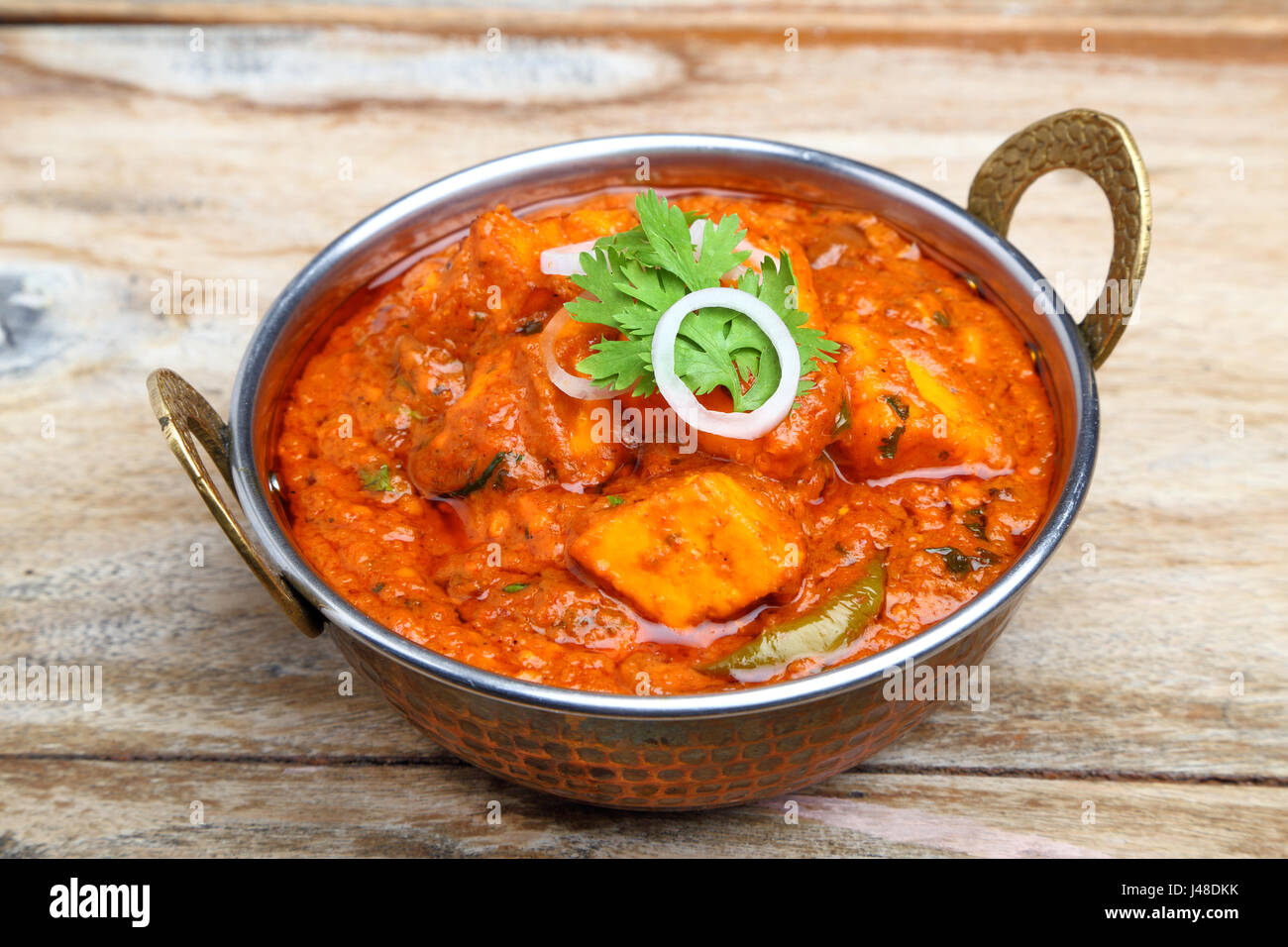 La nourriture indienne ou indien Curry dans un cuivre laiton bol de service. Banque D'Images